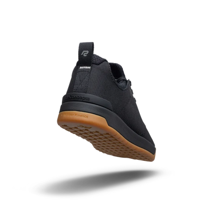 Black athletic shoe with brown sole on a white background