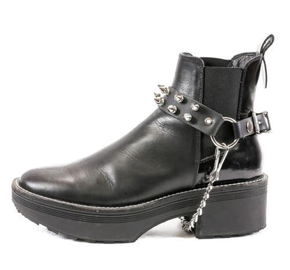 black ankle boot displaying black leather boot strap with two rows of silver tree spikes, single silver o ring and silver hanging chain