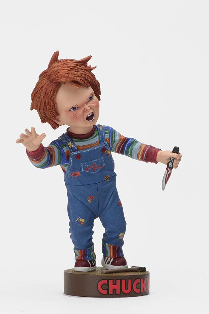 front of Head knocker bobble head of Chucky from Child's Play 2. Chucky has his right hand up, mouth open as if he is yelling, and in his left hand is clutching a knife. Chucky stands on a small round platform that reads "CHUCKY" in red letters on the front.