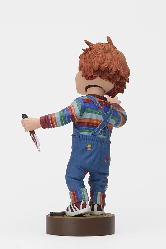back of Head knocker bobble head of Chucky from Child's Play 2. Chucky has his right hand up, mouth open as if he is yelling, and in his left hand is clutching a knife. Chucky stands on a small round platform that reads "CHUCKY" in red letters on the front.