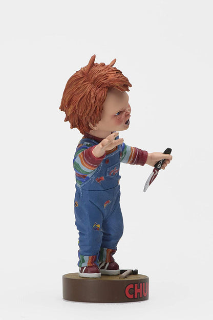 side of Head knocker bobble head of Chucky from Child's Play 2. Chucky has his right hand up, mouth open as if he is yelling, and in his left hand is clutching a knife. Chucky stands on a small round platform that reads "CHUCKY" in red letters on the front.