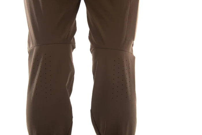 Close-up of a pair of brown technical pants or waders with perforated leg panels, shown against a plain white background.