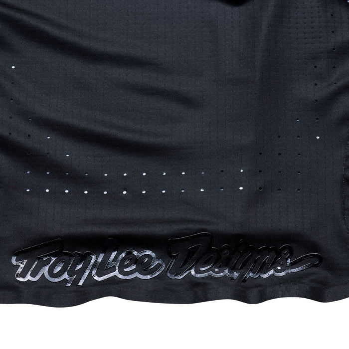 Black sports jersey with 'Troy Lee Designs' branding on a white background