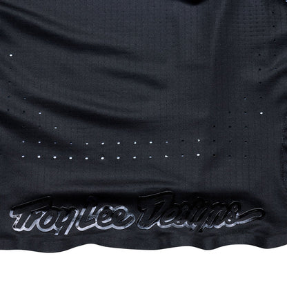 Black sports jersey with 'Troy Lee Designs' branding on a white background