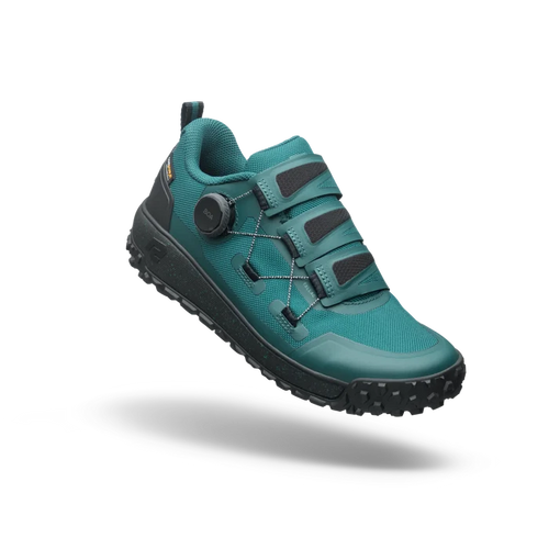 Teal hiking shoe with black sole on a white background